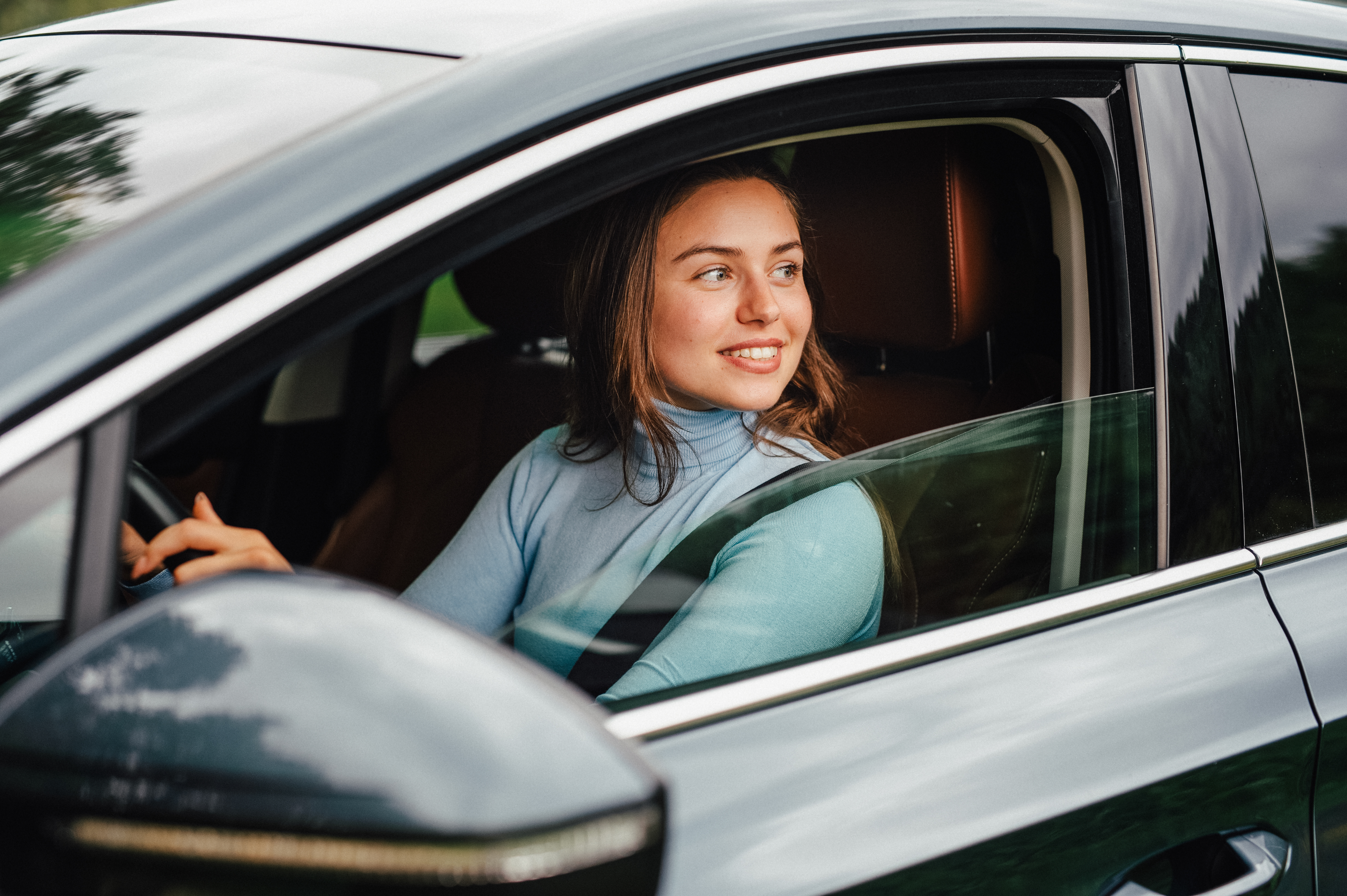 Women gazing out of her car window in the driver's seat